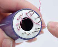 Wire being wrapped around the spokes of the knitter